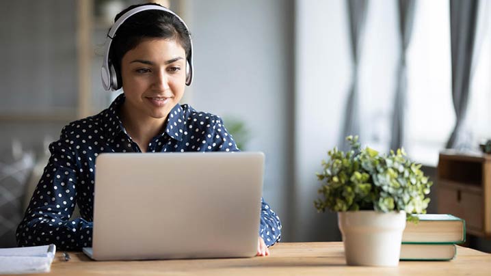 Young Woman Using Headphones Working Remote 718 x 404